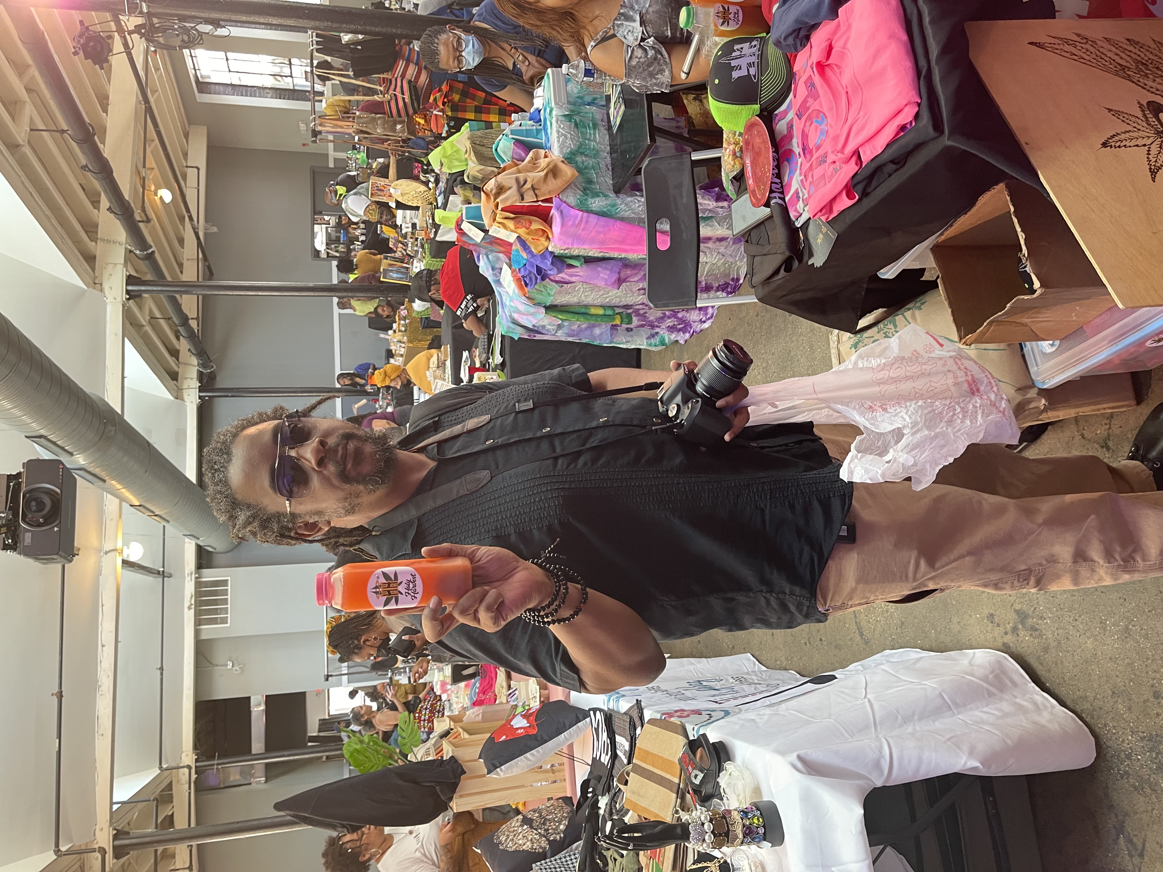Founder holding a lemonade bottle at a busy market